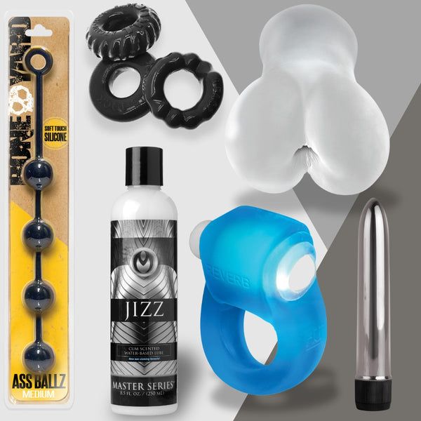 The Boys Behaving Badly collection from Adams Toy Box includes silicone anal beads, a blue vibrating ring, black textured rings, a sleek COLT Metal vibrator, and Jizz lubricant against a gray and white backdrop for an elegant touch.