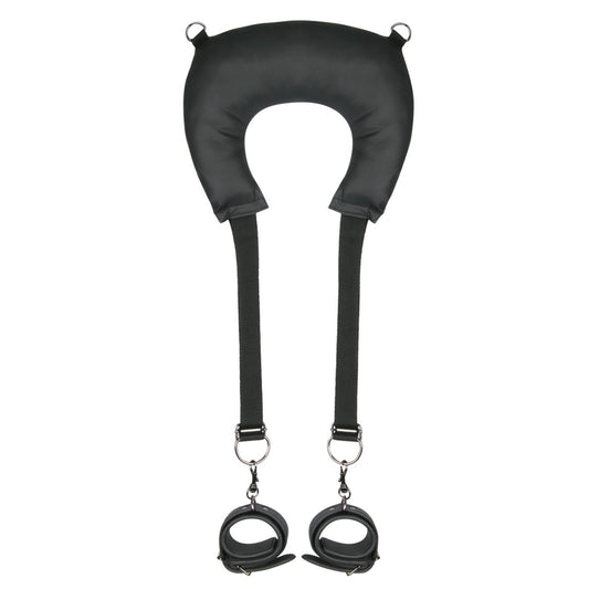The Easy Toys Pillow & Ankle Cuffs Leg Position Strap by Adams Toy Box is a black, faux leather neck support with adjustable straps and attached wrist cuffs, designed for both comfort and restraint.