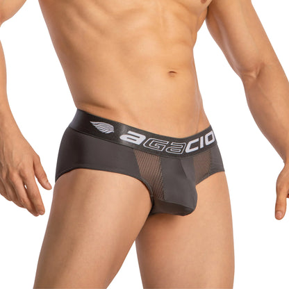 A person wearing Agacio Sheer Boxer Briefs with Pouch, featuring dark gray color, mesh details, and a wide AGACIO waistband. The supportive pouch enhances comfort. Their upper body is partly visible with arms relaxed by their sides.