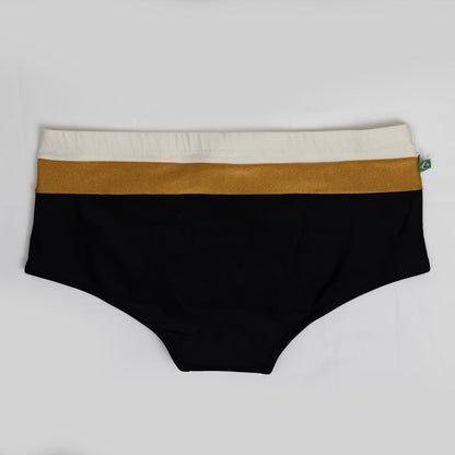 The Belmont Trio Sunga by CA-RIO-CA Sunga Co. boasts high-waisted, luxurious swim bottoms adorned with three horizontal bands: beige at the top, gold in the middle, and black below. A fabric tag is visible on the side.