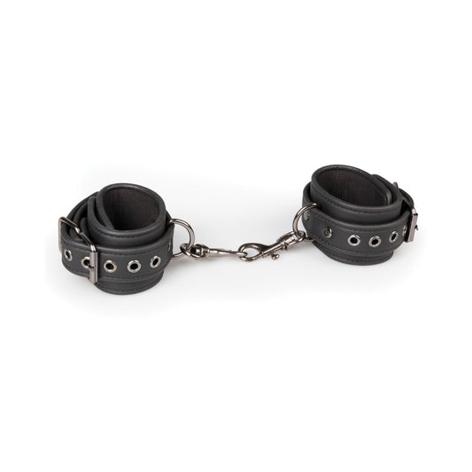 Easy Toys Faux Leather Handcuffs feature black faux leather with adjustable cuffs connected by a short chain and metal clasps. Each cuff includes silver eyelets and buckles for customization, set against a plain white background.